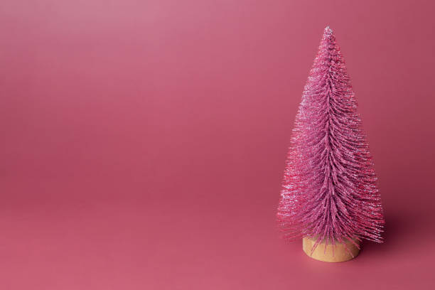 istock Miniature model winter pine tree with shiny is props decoration for create atmosphere Christmas. Christmas decor, christmas tree on pink background. Copy space 1441059663