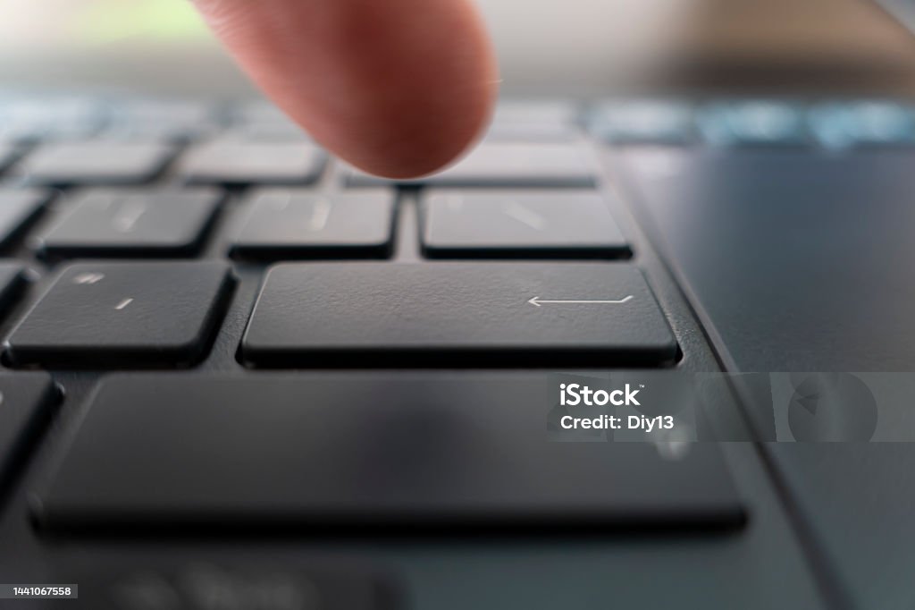 Finger pushing the button of keyboard. Click on black ultrabook key Finger pushing the button of keyboard. Click on the black ultrabook key Pushing Stock Photo