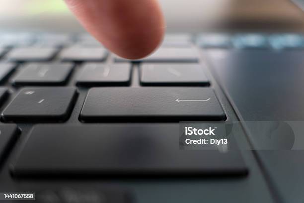 Finger Pushing The Button Of Keyboard Click On Black Ultrabook Key Stock Photo - Download Image Now