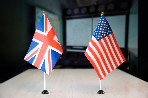 flags of United States and United Kingdom. international negotiations. conclusion of contracts between countries. concept of communication between representatives of two countries. Geopolitical