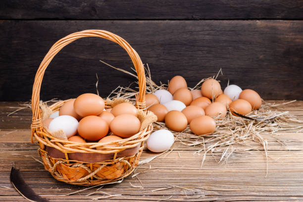 istock Chicken eggs in a basket placed on a wooden table, rural farm 1441073347