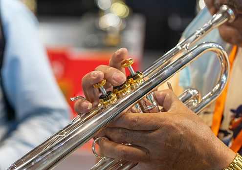 Trumpet player playing jazz musician. Woman playing trumpet brass instrument isolated on black