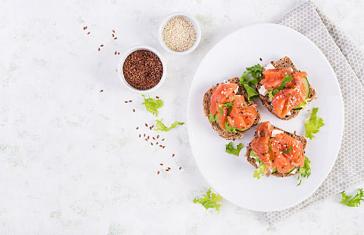 Open sandwiches with salted salmon, cheese cream and fresh cucumber. Seafood. Healthy food. Top view.