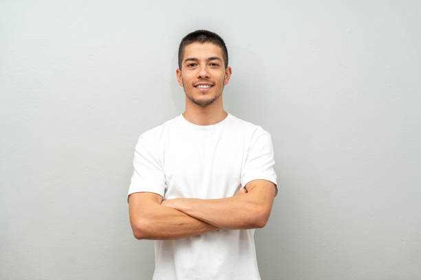 Portrait of young man in front of gray wall stock photo