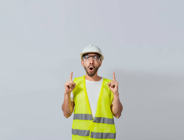 istock Surprised young architect pointing up, Amazed engineer pointing at an advertisement. Concept of an engineer with astonished face pointing at blank space, Amazed engineer man pointing up 1441095446