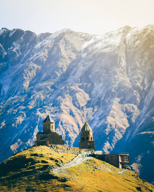 istock Stepantsminda, Gergeti, Georgia. Famous Gergeti Trinity Tsminda Sameba Church In Early Winter Landscape. Suv Moving Near Church In Beautiful Georgian Landscape In Early Winter 1441095641