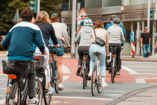 Many Cyclists cross the street and the road at the intersection at the traffic light signal. Road rules safety concept