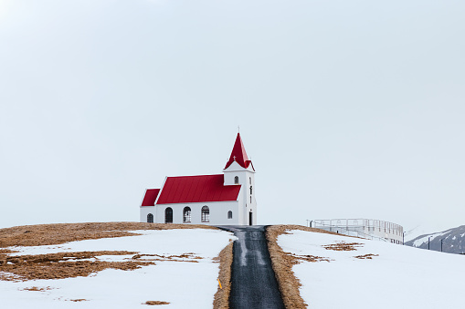 The historic Ingjaldshóll Church on top of the hill in Wintertime. The church at Ingjaldsholl serves the villages Hellisandur and Rif and is the oldest concrete church in the world. Christopher Columbus seems to have stayed at Ingjaldshóll during the winter of 1477-78. Ingjaldshólskirkja - Ingjaldsholl Church, Snæfellsnes Peninsula in West-Iceland, Iceland, Northern Europe.