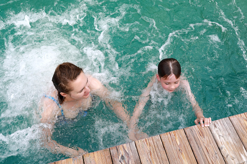 Mother and son do their chests hydromassage in thermal pool, Adygea