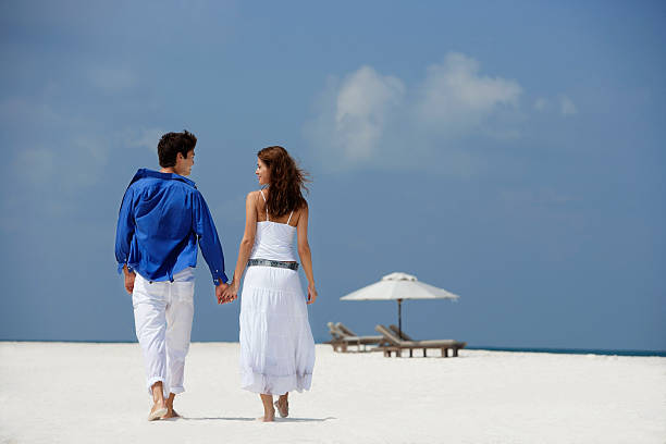 couple holding hands on beach  malay couple full body stock pictures, royalty-free photos & images