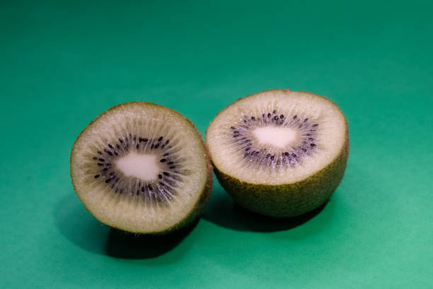 Organic green kiwi fruit slices isolated on green background
