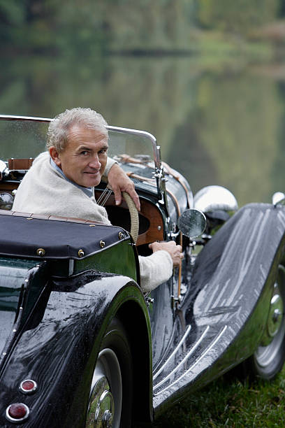 starszy mężczyzna siedzi w zabytkowych samochodów - old men car vertical zdjęcia i obrazy z banku zdjęć