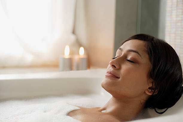 woman reclining in bathtub - bathtub ภาพสต็อก ภาพถ่ายและรูปภาพปลอดค่าลิขสิทธิ์