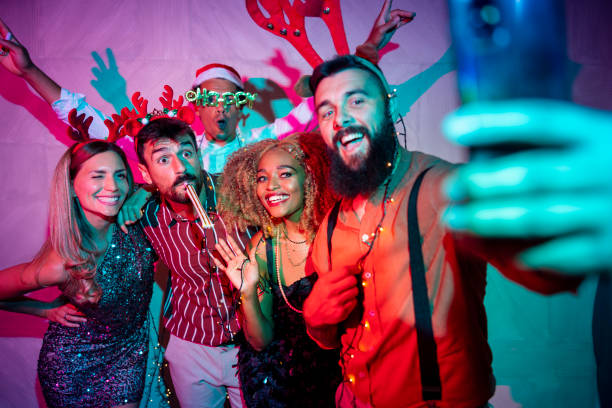 Friends taking a selfie while having fun at New Year party stock photo
