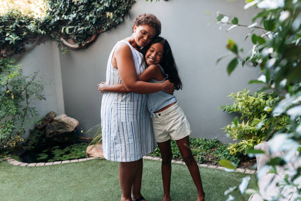 istock Granny and granddaughter embracing each other while standing in backyard 1441110775