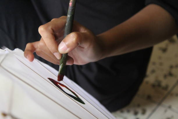 istock A hand painting with a paintbrush 1441115318