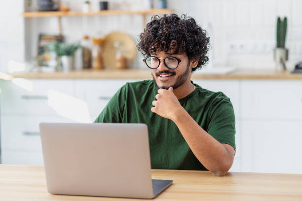 istock Smiling man student or freelancer using laptop computer to watch online webinar or training, education, studying, distance learning at home 1441117529