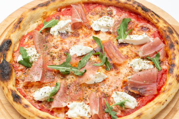 istock Delicious Italian pizza with ham, cheese, arugula and tomatoes. 1441117896