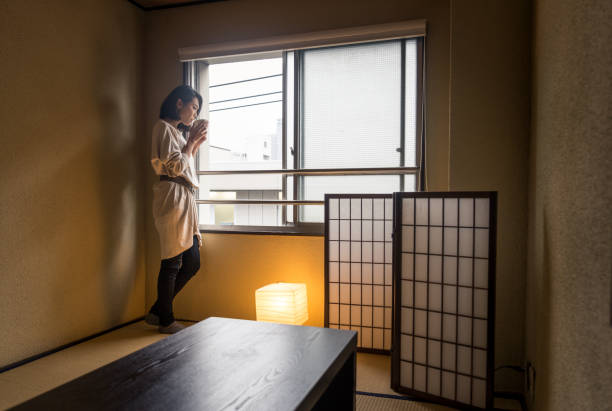 Japanese woman sitting in a traditional Tokyo apartment and drinking a cup of hot tea
