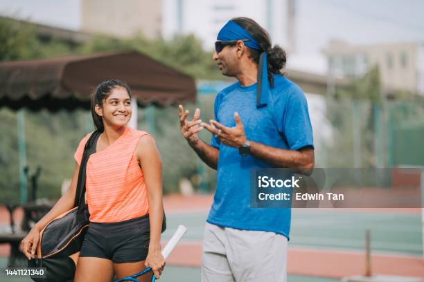 Asian Indian Coach Talking To Female Adult Student Leaving After Practicing In Tennis Hardcourt Stock Photo - Download Image Now