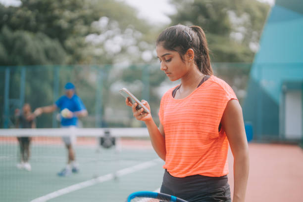 테니스 코트에서 아시아 인도 여자가 경기 후 스마트폰 문자 메시지를 확인 - tennis women one person vitality 뉴스 사진 이미지