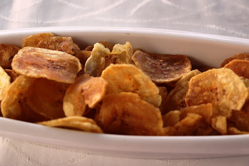 heap of potato chips with paprika, isolated on white