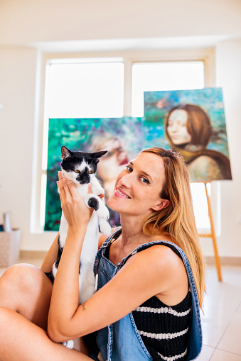 Woman holding her cat and smiling at the camera for a photograph