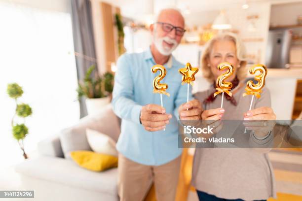 Senior Couple Holding Numbers 2023 For New Year Home Party Stock Photo - Download Image Now