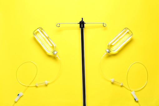 IV infusion set on yellow background, flat lay