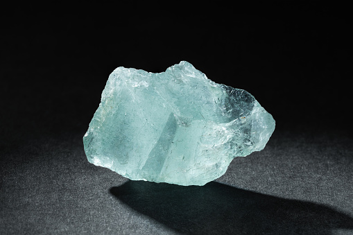 Rough Uncut Pale Blue Aquamarine Gemstone on Black Background. Healing Breath Stone is Believed to Cure Respiratory Problems