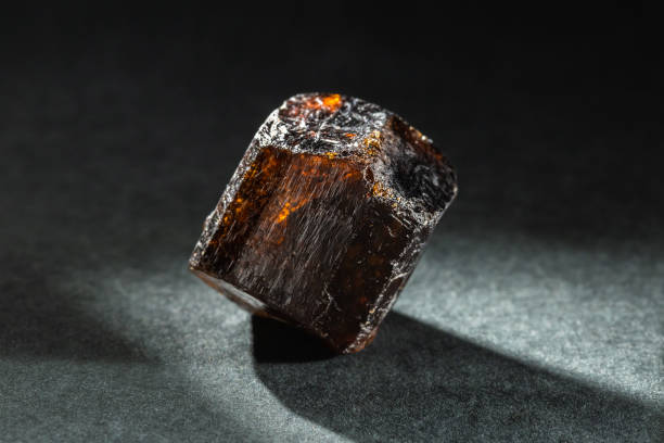 Brown Dravite Tourmaline Crystal Back Lit on Black Unpolished Brown Dravite Tourmaline Crystal Back Lit on Black Background crystalline inclusion complex stock pictures, royalty-free photos & images