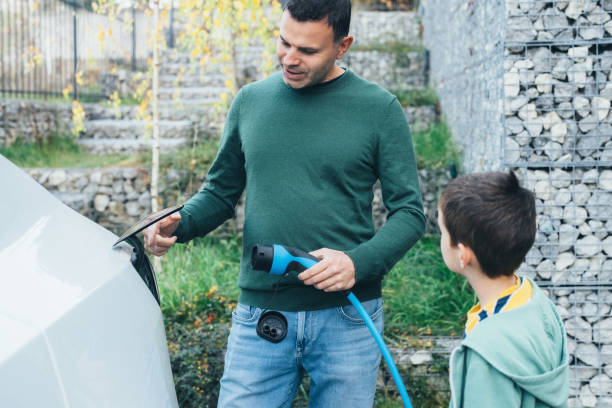 istock Father and son charging new electric car at home 1441127601