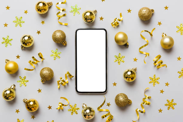 istock Christmas online shopping from home phone with blank white display top view. smart mobile with copy space on colored background with Christmas decorations balls,. Winter holidays sales background 1441127719