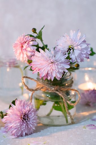 Small bouquet of chrysanthemum in glass jar and candle