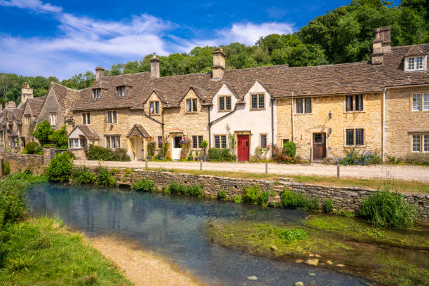 castle combe village and by brook river, wiltshire in the england cotswolds uk - castle combe imagens e fotografias de stock