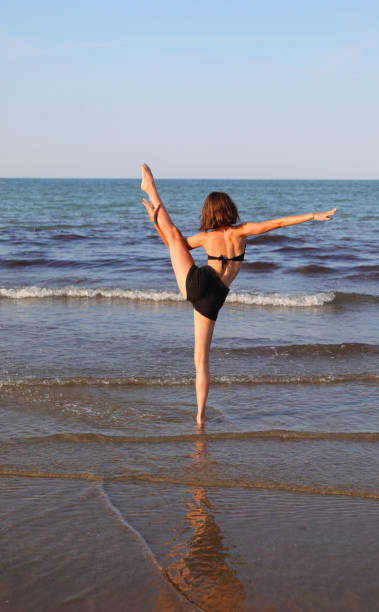 istock young slim athletic girl performs gymnastic exercises in summer 1441132998