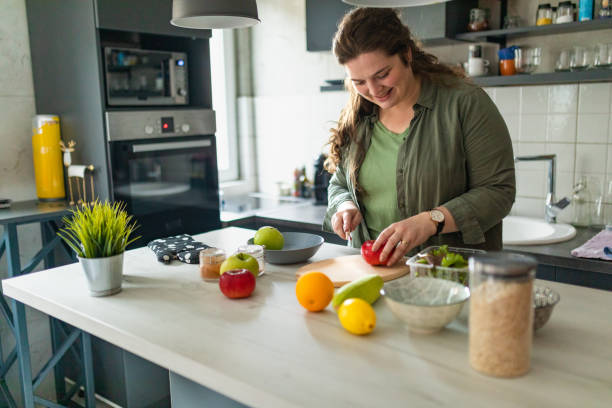 istock Woman cutting apple while preparing healthy breakfast at home 1441135483