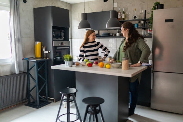 istock Friends having fun while preparing smoothie in kitchen at home 1441135527