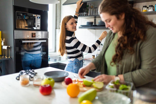 istock Friends having fun while preparing smoothie in kitchen at home 1441135583