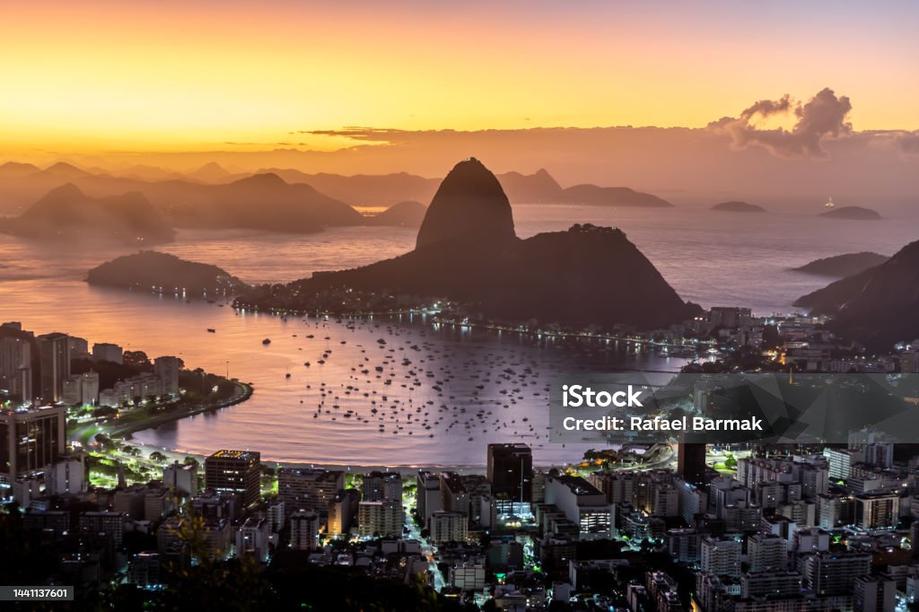 Sugarloaf mountain under a pink sky Aerial view of the Sugarloaf mountain touching the waters of the Guanabara bay, Rio de Janeiro, under the pink skies of a rising sun Rio de Janeiro Stock Photo