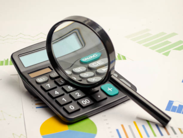 istock Calculator seen through magnifying glass 1441138212