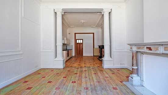 Empty apartment with two classical fireplaces and designed hardwood floor after renovation