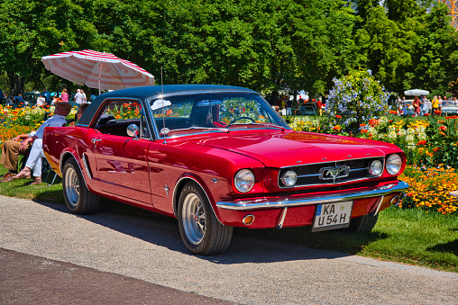 Baden-Baden, Germany - 10 July 2022: red Ford Mustang coupe first generation 1964 1973, oldtimer meeting in Kurpark.