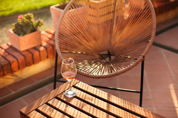 Wineglass on brick border in yard High angle of glass of wine placed on brick barrier on sunny summer day in yard crystal chalice stock pictures, royalty-free photos & images