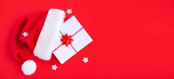 istock banner gift box in a hat santa claus on a red background top view with place for text 1441140415
