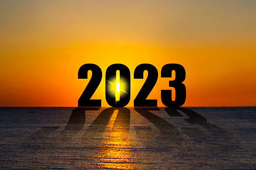 Silhouette of the numbers 2023, over the ocean, at sunrise. Concept of the coming New Year. Happy New Year banner.