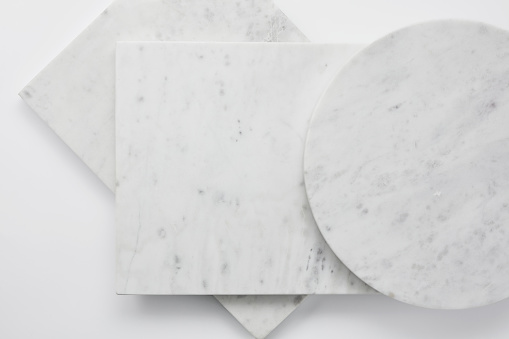 White gray empty marble boards of various shapes. Square and round marble slabs. Flat lay