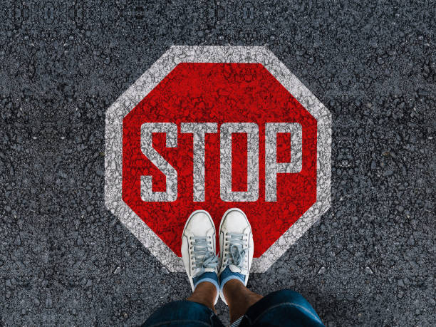 istock legs in sneakeers and stop sign 1441145643