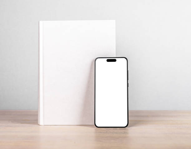 istock Book cover mock up and iphone 14, smart phone mockup on wood table 1441151477