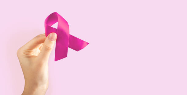 istock Hand holding pink fabric ribbon on ad background, banner 1441151533